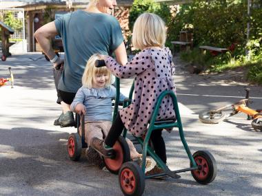 Voksen cykler med barn